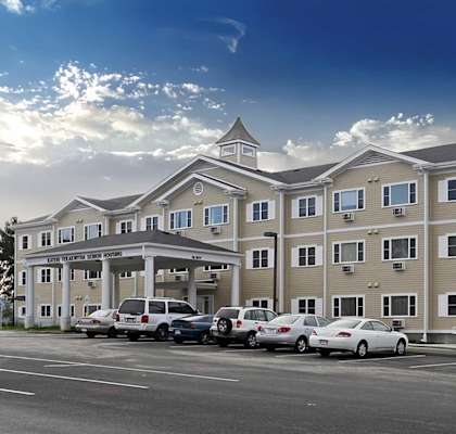 A large apartment complex with a parking lot in front.