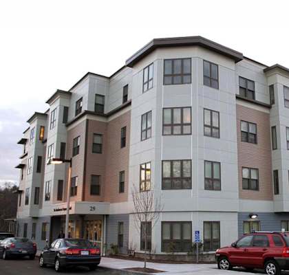 Apartment building with cars parked in front.