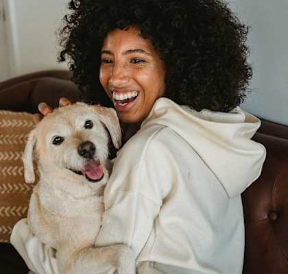a woman sitting on a couch with a dog
