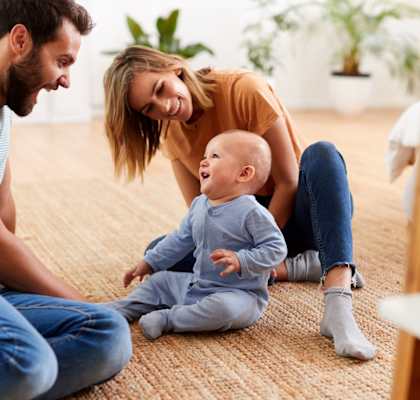 Mother and Father Smiling while Playing with Baby