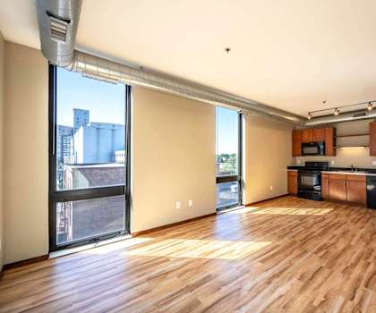 an open living room with a kitchen and a large window