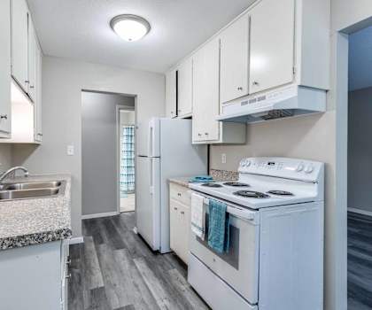 A kitchen with white appliances and cabinets.