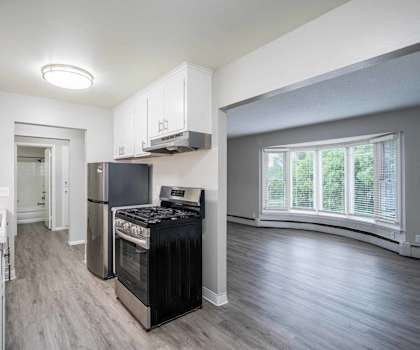 A kitchen with a black stove top oven and a white fridge.