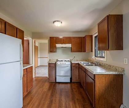 A kitchen with wooden cabinets and a white refrigerator.