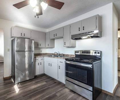 A kitchen with a stainless steel refrigerator, oven, and microwave.