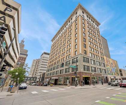 A street view of a city with a large building in the center.