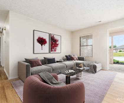 A living room with a grey couch and a red armchair.