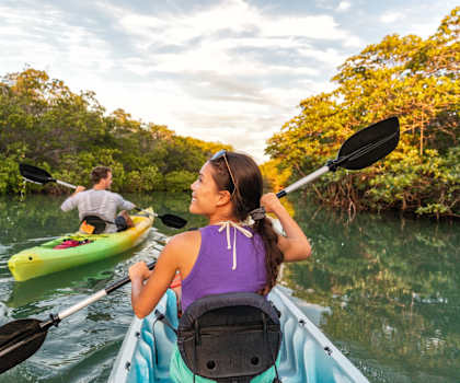 Man and Woman Kayaking on River Together Smiling