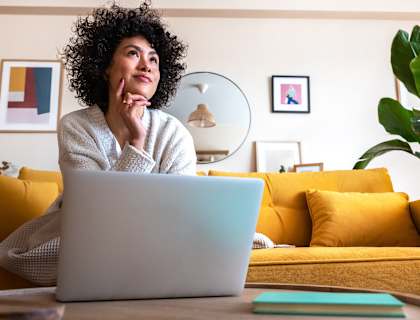 a woman sitting on a couch with a laptop in front of her