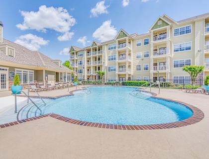 a swimming pool with an apartment building in the background