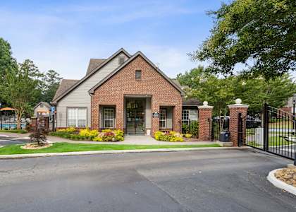A brick house with a black gate in front.