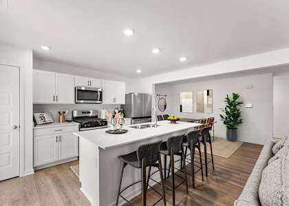 A modern kitchen with white cabinets and a large island.