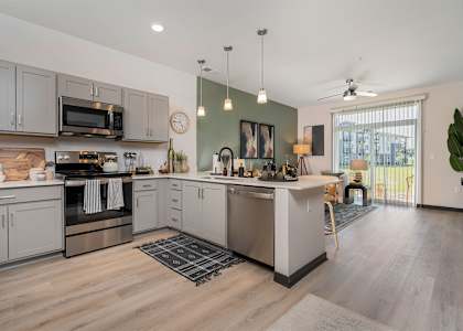 A kitchen with a wooden floor and stainless steel appliances.