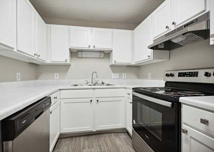 A kitchen with white cabinets and appliances.