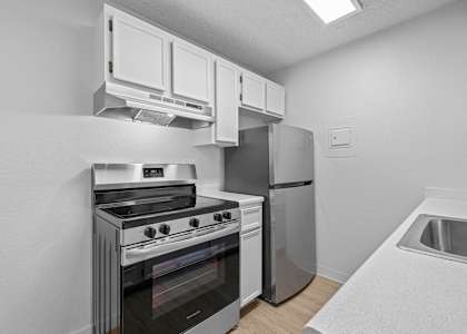 A modern kitchen with a stainless steel oven and refrigerator.