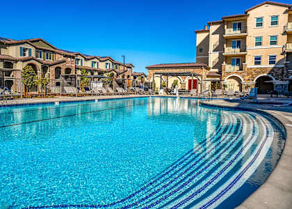 A large swimming pool in front of apartment buildings.