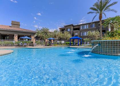 A swimming pool with a fountain in the middle of it.