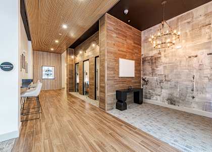 A hallway with a wooden floor and a stone wall