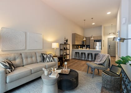 A modern living room with a grey sofa and a coffee table at Center Square Lofts West, Allentown, PA