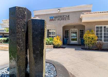 a building with a fountain in front of leasing office at waterson at murrieta