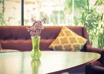 a table in a living room with a vase of flowers