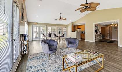 a living room with blue chairs and a glass coffee table