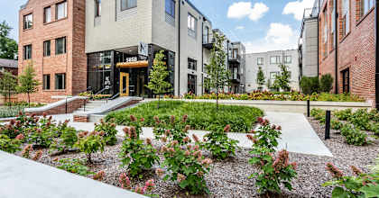 a view of the front of the building with landscaping and a staircase leading to the entrance at The MK, Indiana