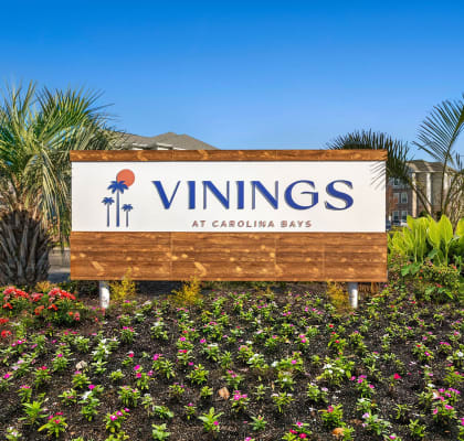 a sign for the vinings at carolina blvd in front of plants