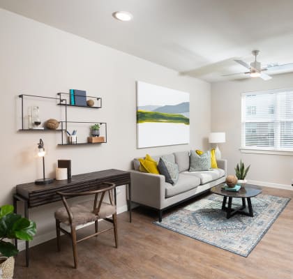 a living room with a ceiling fan and hardwood flooring at 55 Fifty at Northwest Crossing, Houston