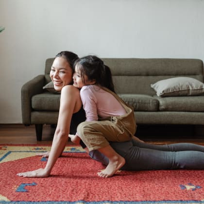 a mother and daughter sitting on a rug in a living room