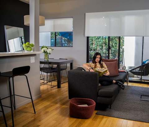 A woman is sitting on a couch in a living room.