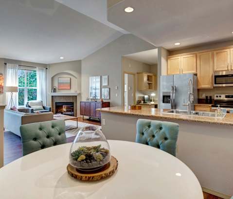 A modern kitchen with a dining table in the middle.