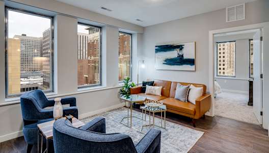 A living room with a couch, chairs, and a coffee table.