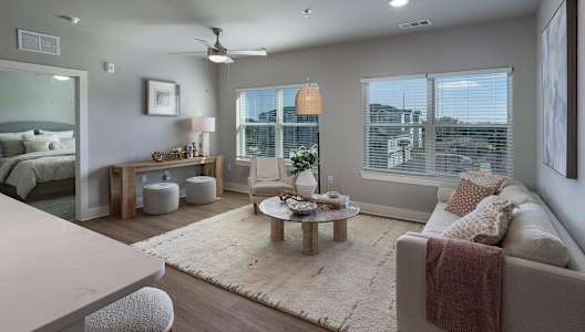 A well-lit, modern living room with a large couch and a coffee table.