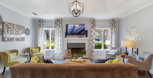 A living room with a brown couch and a chandelier at The Onyx Hoover Apartments, Hoover, AL, 35216