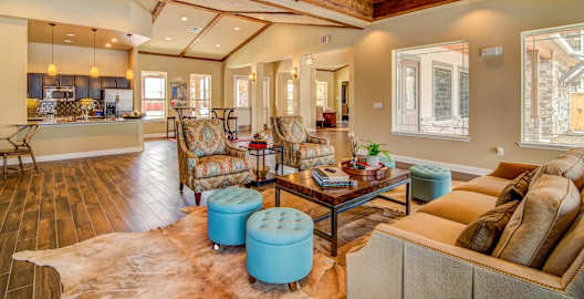a living room with a coffered ceiling and a kitchen in the background at Villa Espada Apartments, San Antonio, Texas