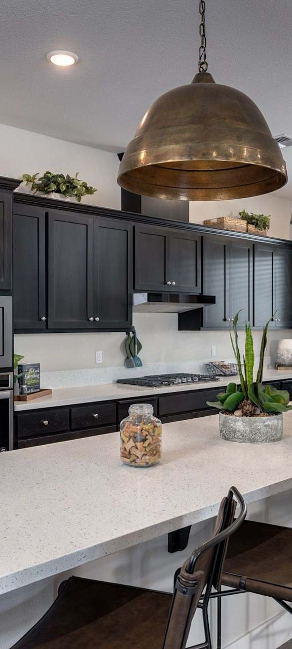 a kitchen with stainless steel appliances and a large island with chairs at Heritage Landing Apartments, Chico, CA
