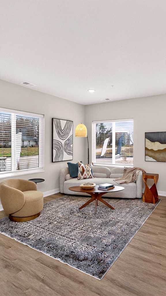 A living room with a large rug and a wooden bench.