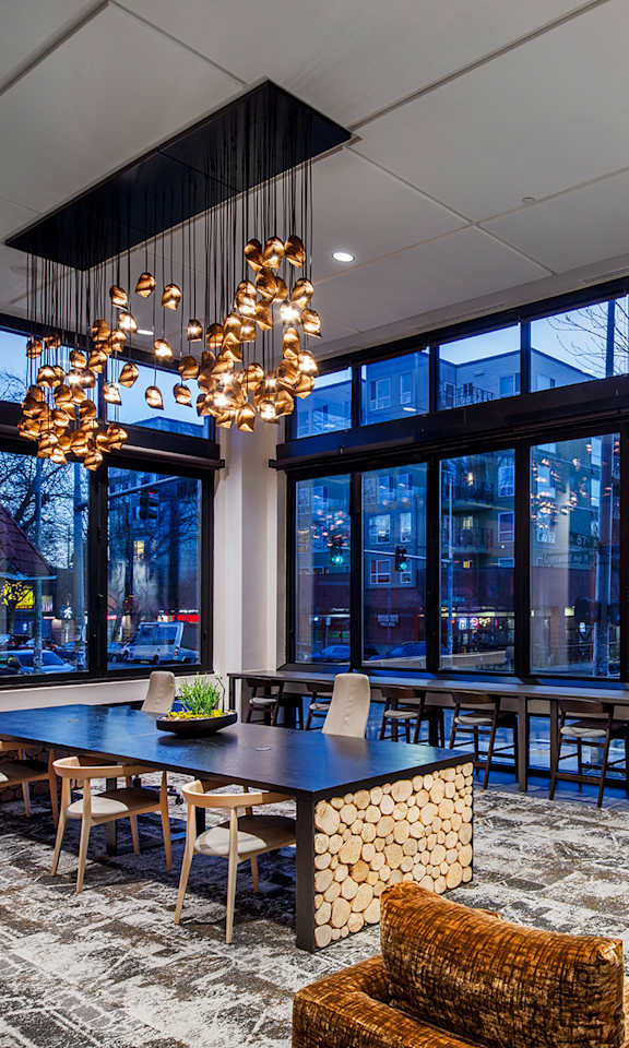 A modern living room with a large window and a chandelier.