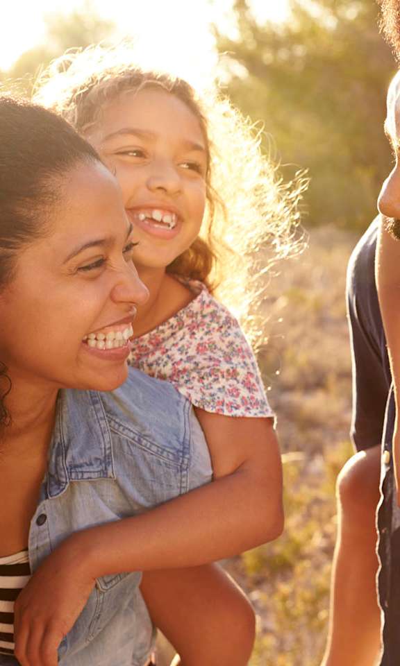 A family of three is enjoying a sunny day outdoors.