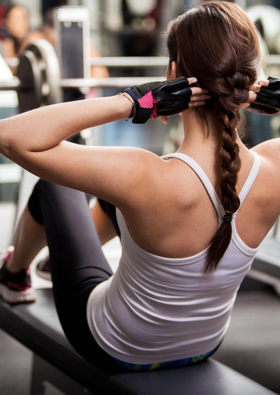 a woman doing a bench press in a gym