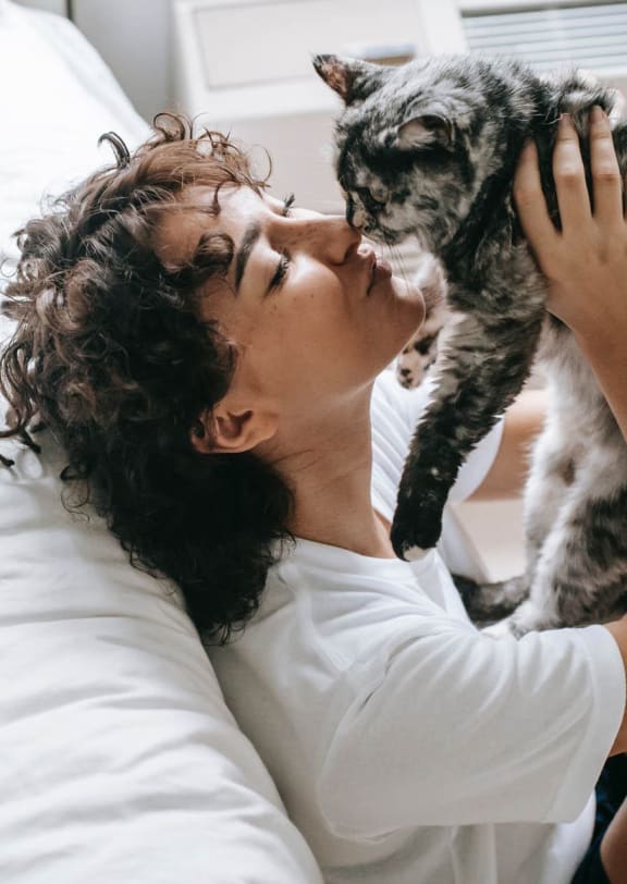 a woman laying in bed with her cat
