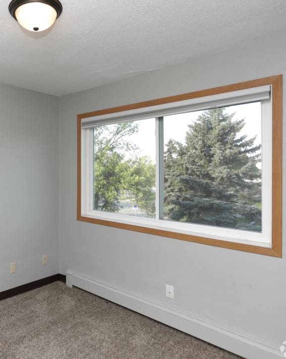 a bedroom with a large window and a white door