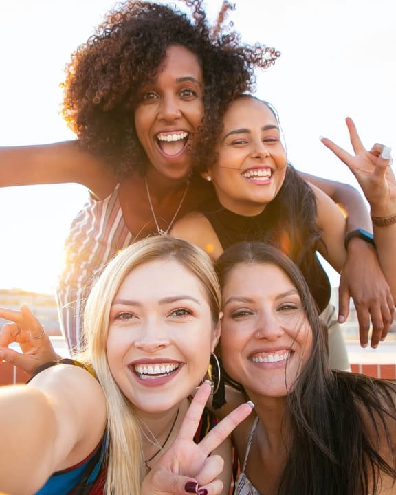 a group of women posing for a photo on a bridge