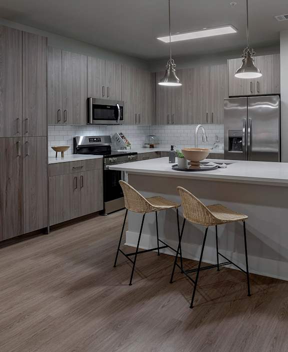 A modern dining area with a stone wall and a television at The Waverly at Winter Haven Apartments, Winter Haven, 33884