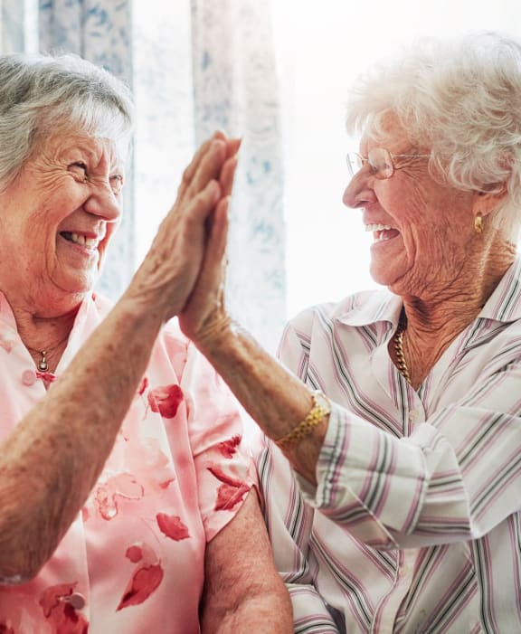 an older woman and a younger woman giving a high five