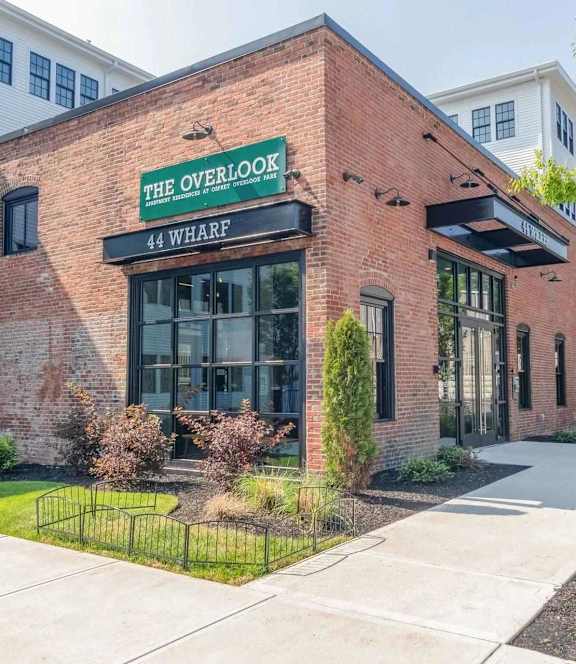 Brick building exterior with community entrance sign at The Overlook Apartments, Weymouth, MA 02188