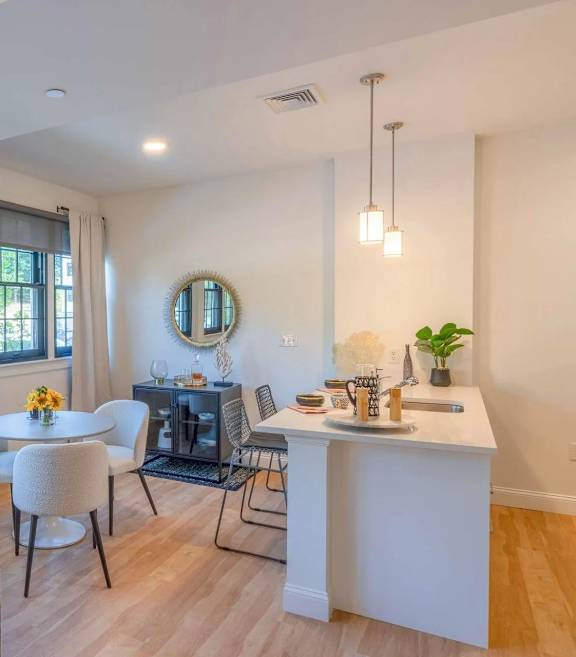 Open dining area with white round table and chairs at The Overlook Apartments, Weymouth, MA
