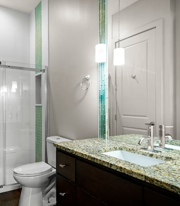 State Street Flats Apartments bathroom with a toilet, sink, and shower.