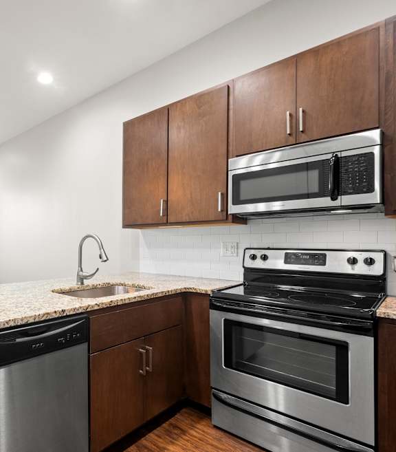 State Street Flats Apartments kitchen with a stove, oven, dishwasher, and microwave.